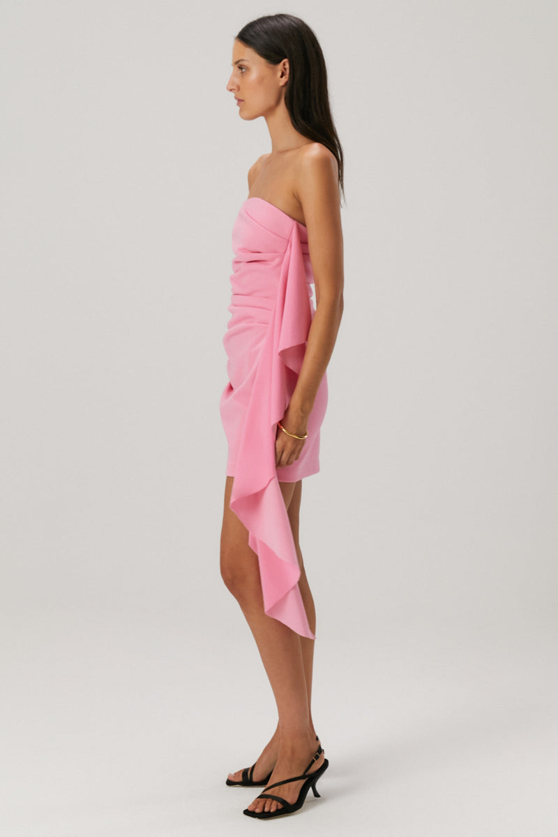 Lady in a pink bonded crepe mini dress with a satin flounce seam.