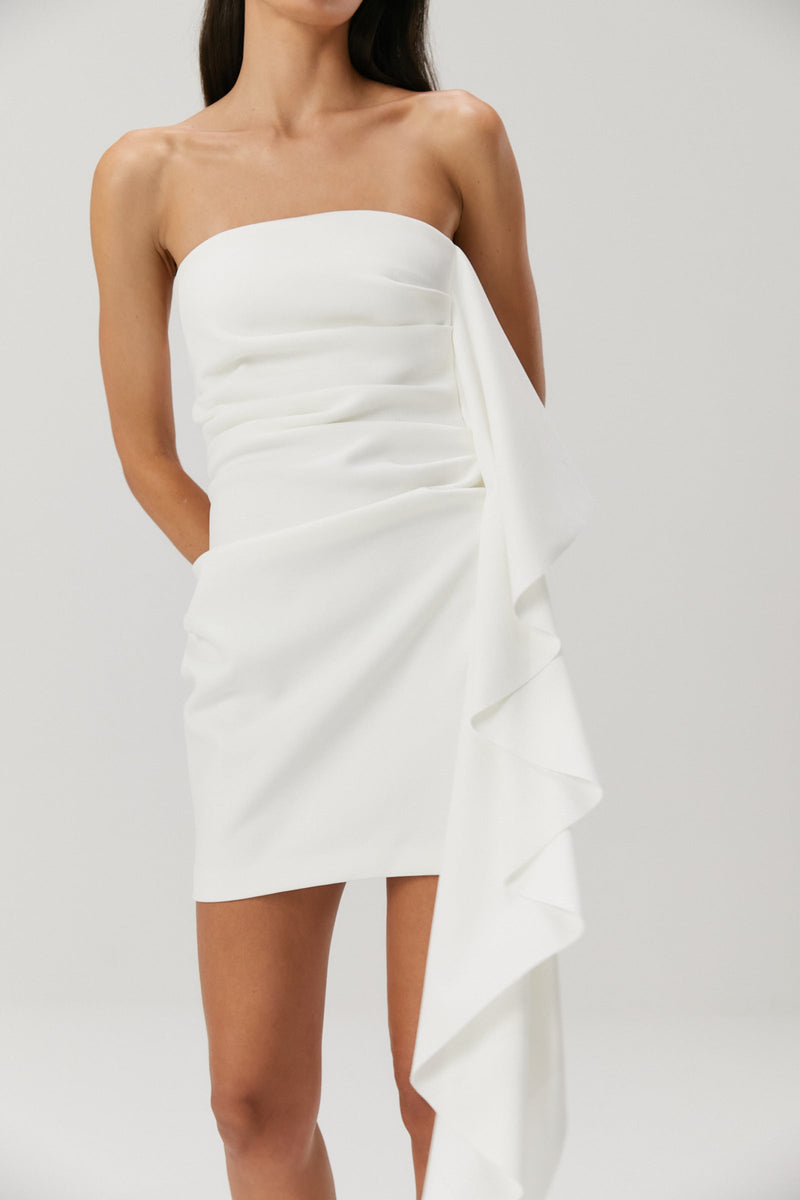 Lady in an ivory bonded crepe mini dress with a satin flounce seam.