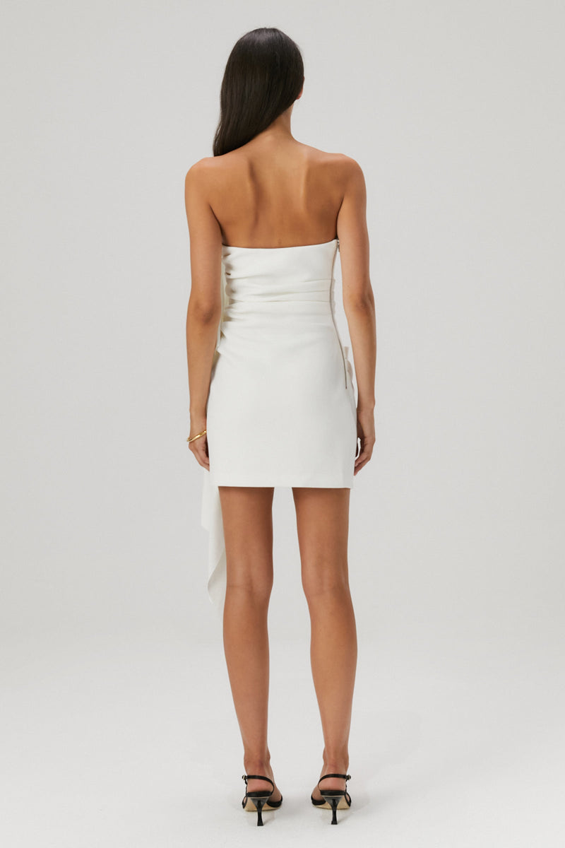 Lady in an ivory bonded crepe mini dress with a satin flounce seam.