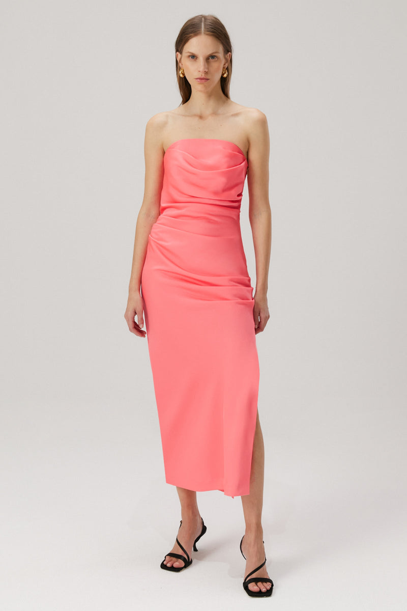 Girl with blonde hair wearing a pink strapless midi dress in a satin material. 