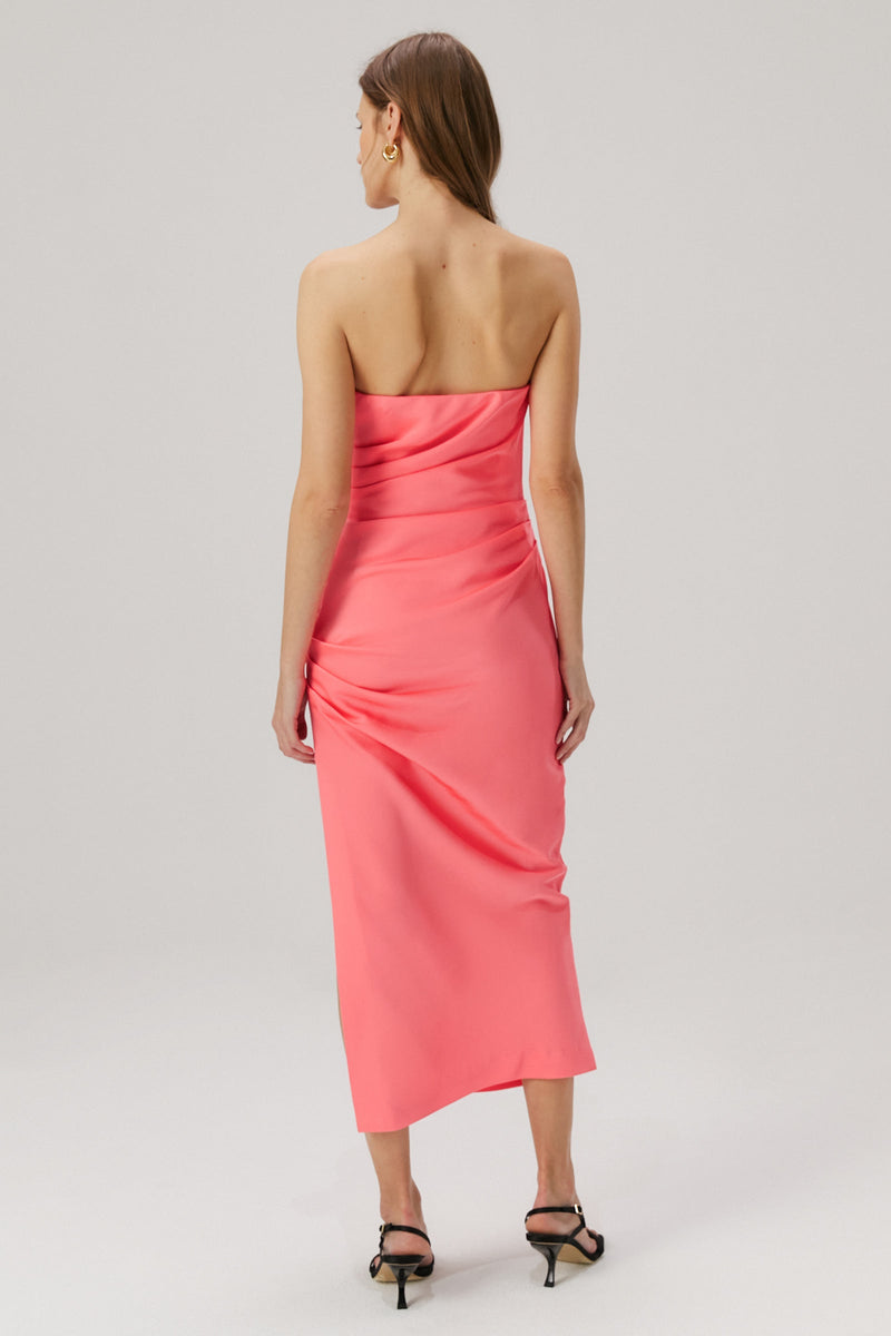 Girl with blonde hair wearing a pink strapless midi dress in a satin material. 