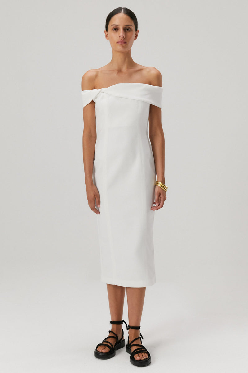 Brown hair girl wearing an off the shoulder bonded crepe midi dress in an ivory colour. 