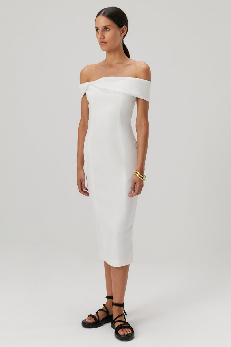 Brown hair girl wearing an off the shoulder bonded crepe midi dress in an ivory colour.